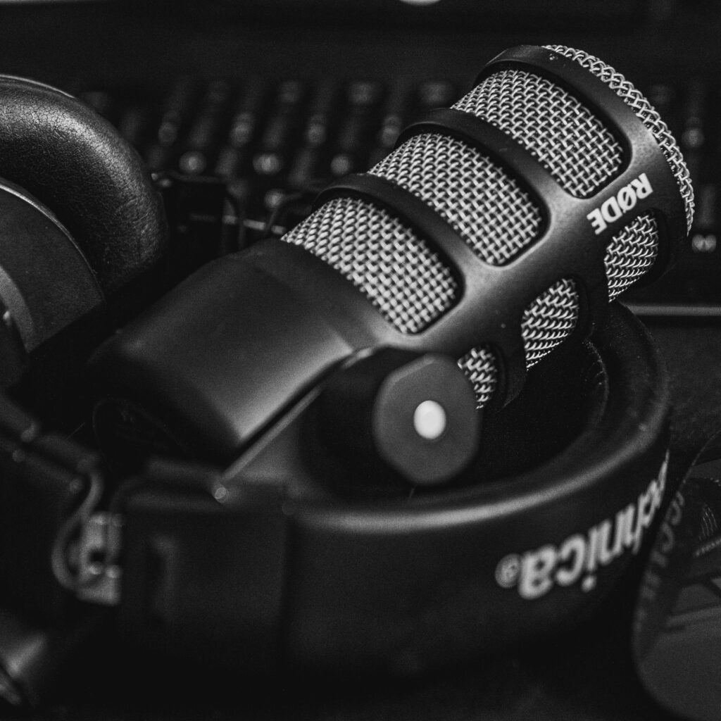 Close-up of a studio microphone and headphones in a black and white composition, perfect for audio and podcast themes.